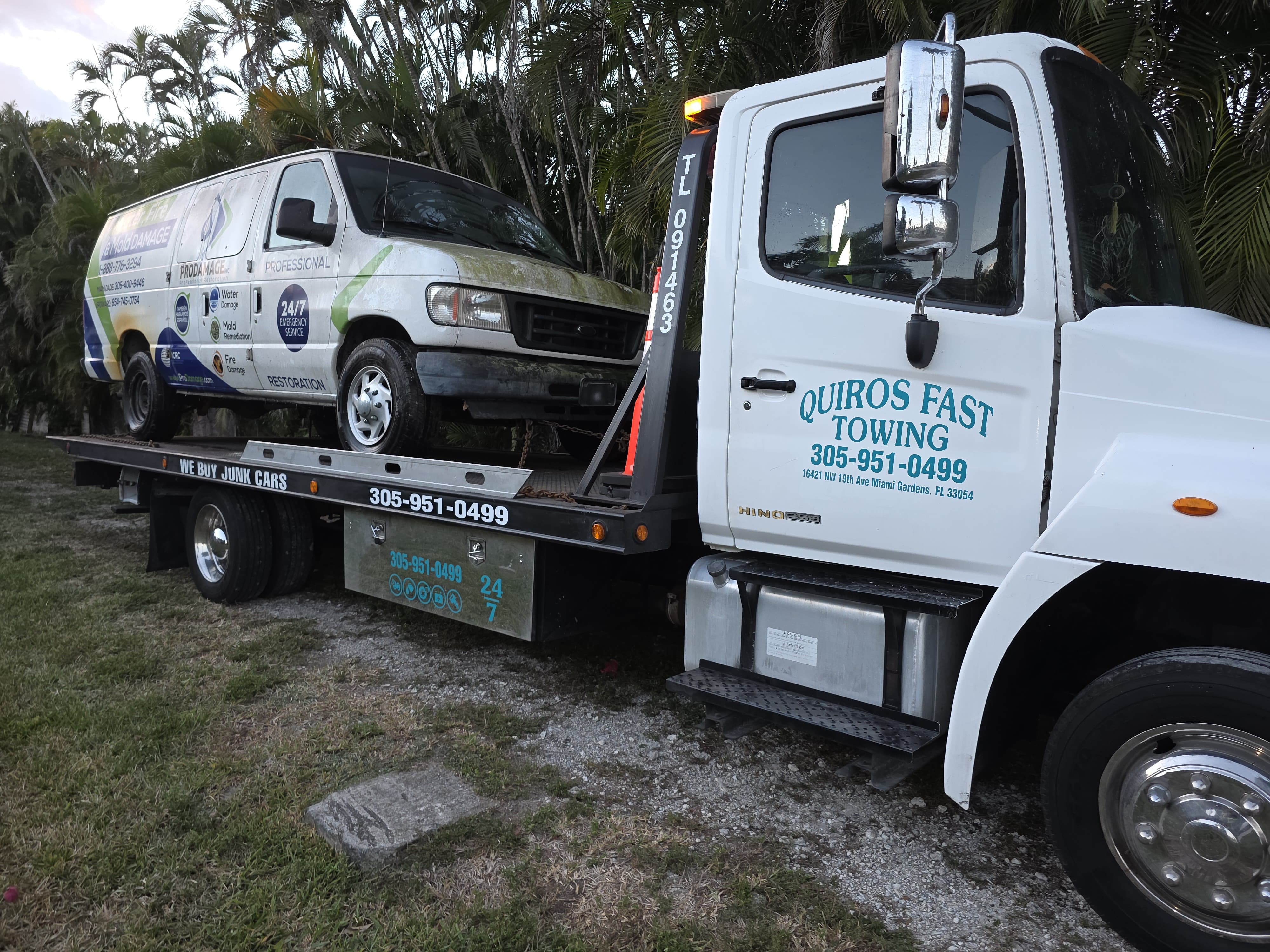 Isuzu NPR box truck on flatbed at night