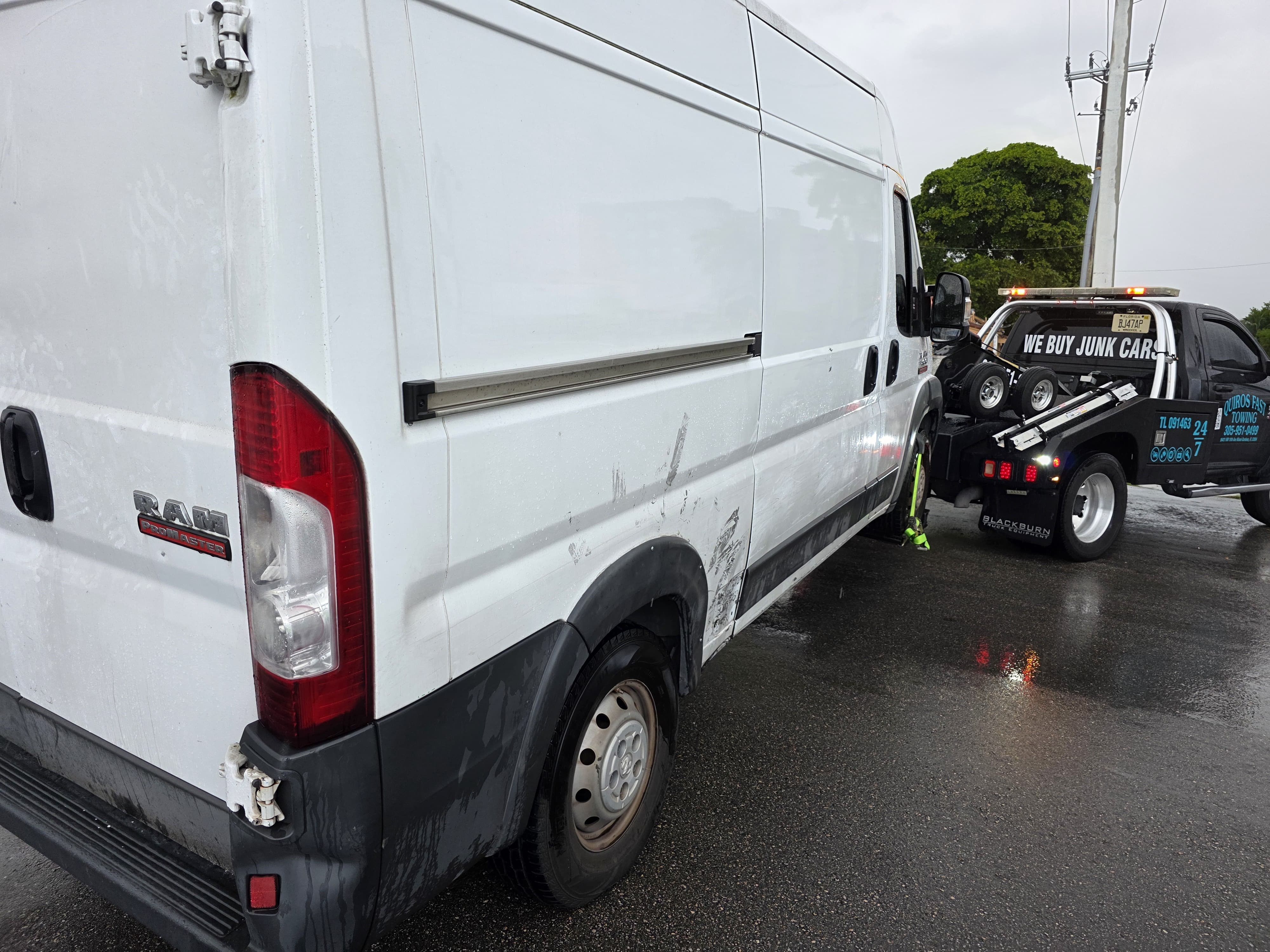 White Ram ProMaster commercial van being towed in the rain