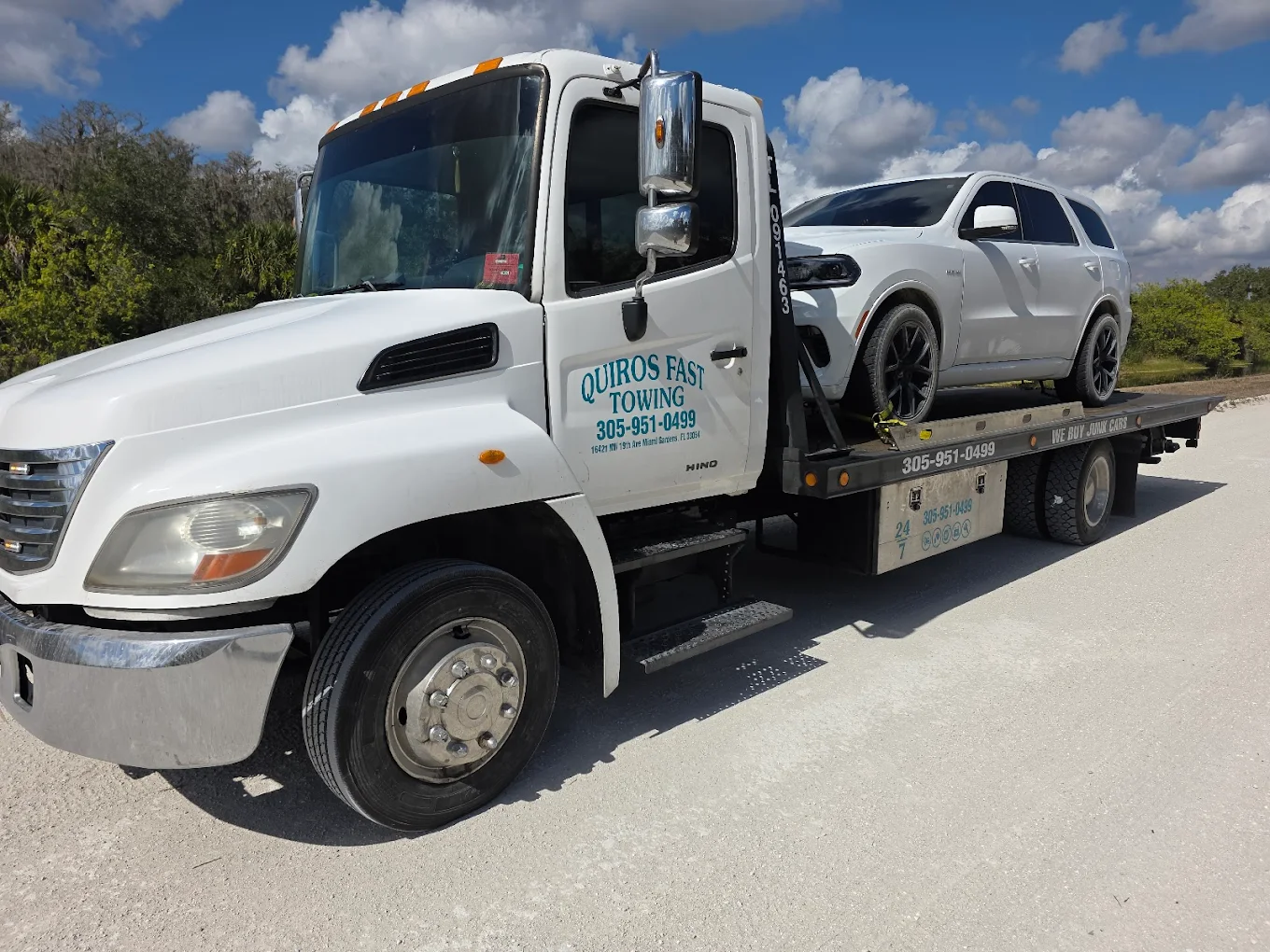 Hino flatbed transporting a Dodge Durango